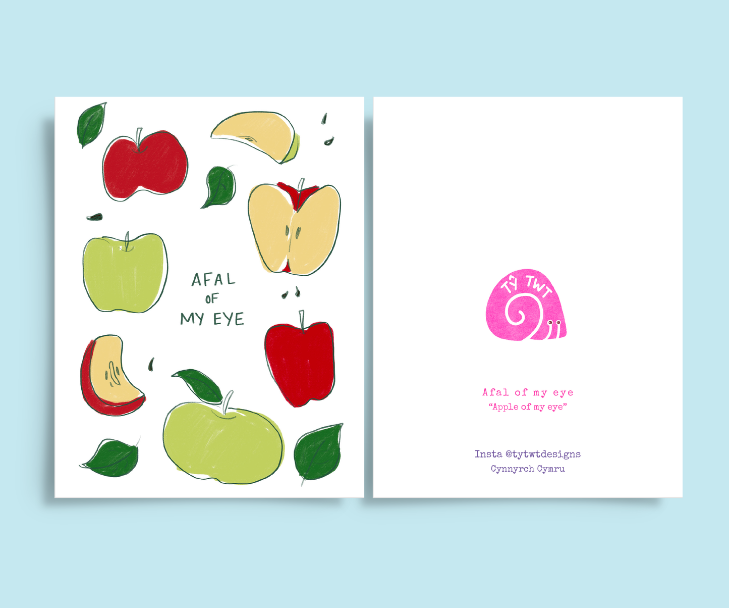Light blue background and front and back of greeting card. Left side is apples illustration with handwritten Afal of my eye and left is Welsh to English translation in typewriter font. Instagram @tytwtdesigns made in Wales