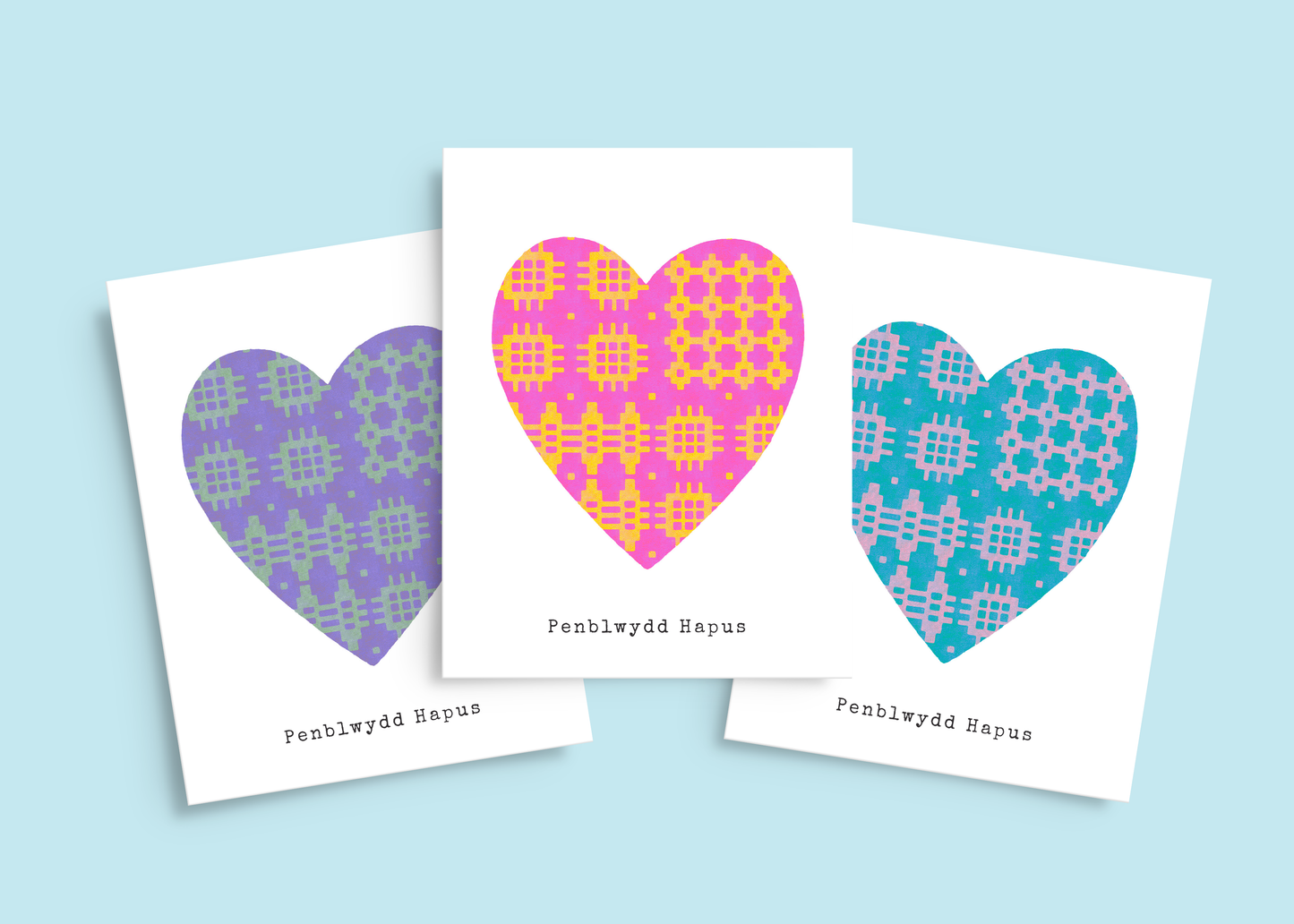 Set of three Welsh birthday cards in pink & yellow, purple & green, and blue & lilac, all featuring traditional blanket pattern hearts.