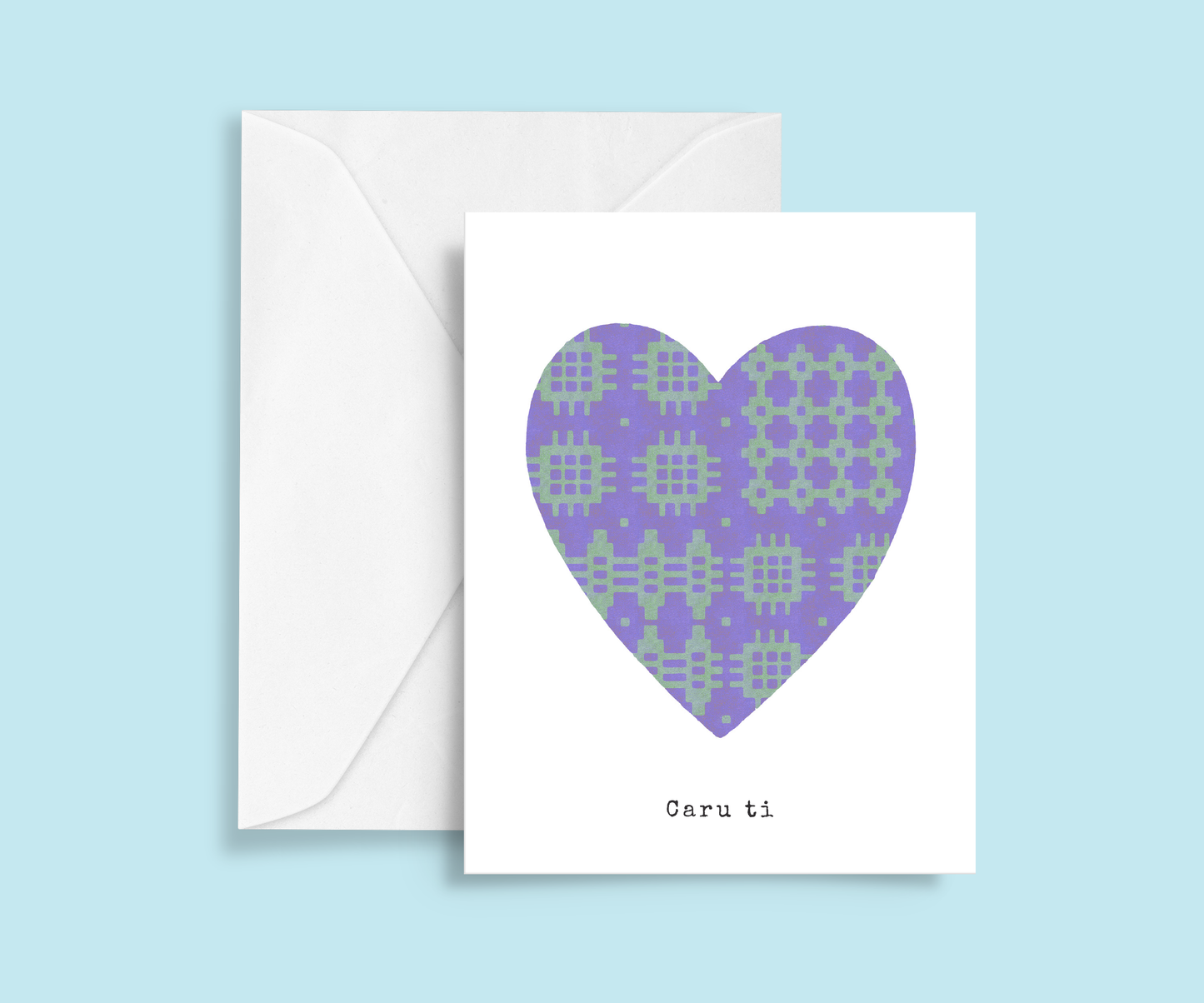 A minimalist romantic card featuring a purple and green Welsh blanket patterned heart in the centre with typewriter-style 'Caru ti' text below.  Meaning Love you.