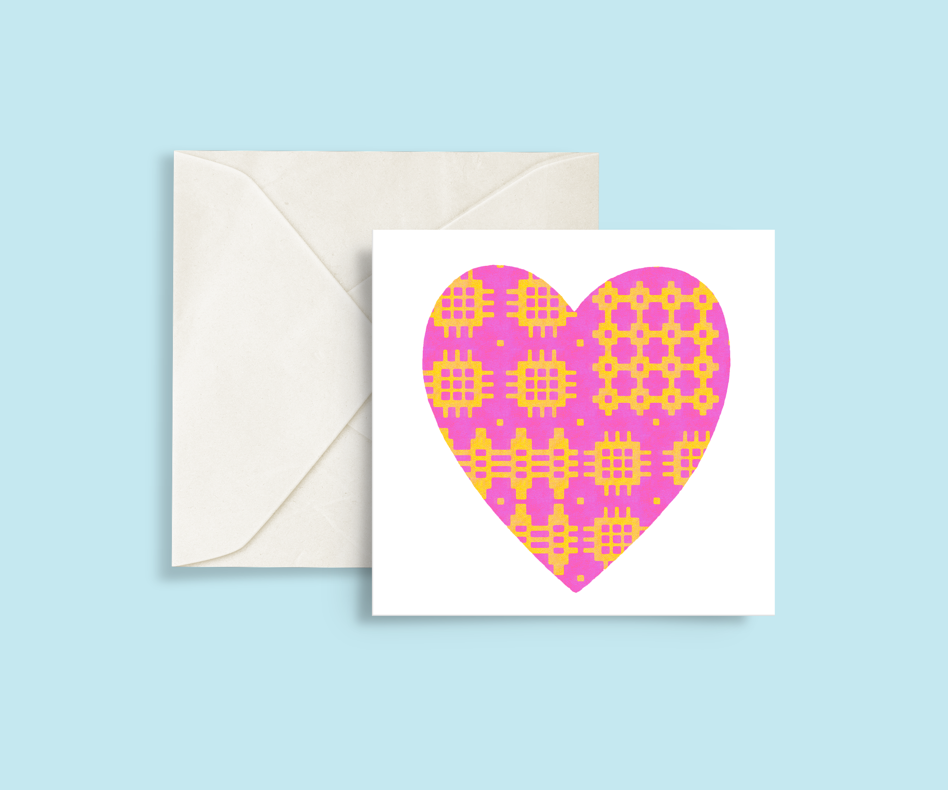 A minimalist card featuring a pink and yellow Welsh blanket patterned heart in the centre.