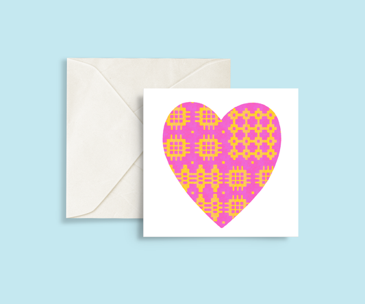 A minimalist card featuring a pink and yellow Welsh blanket patterned heart in the centre.
