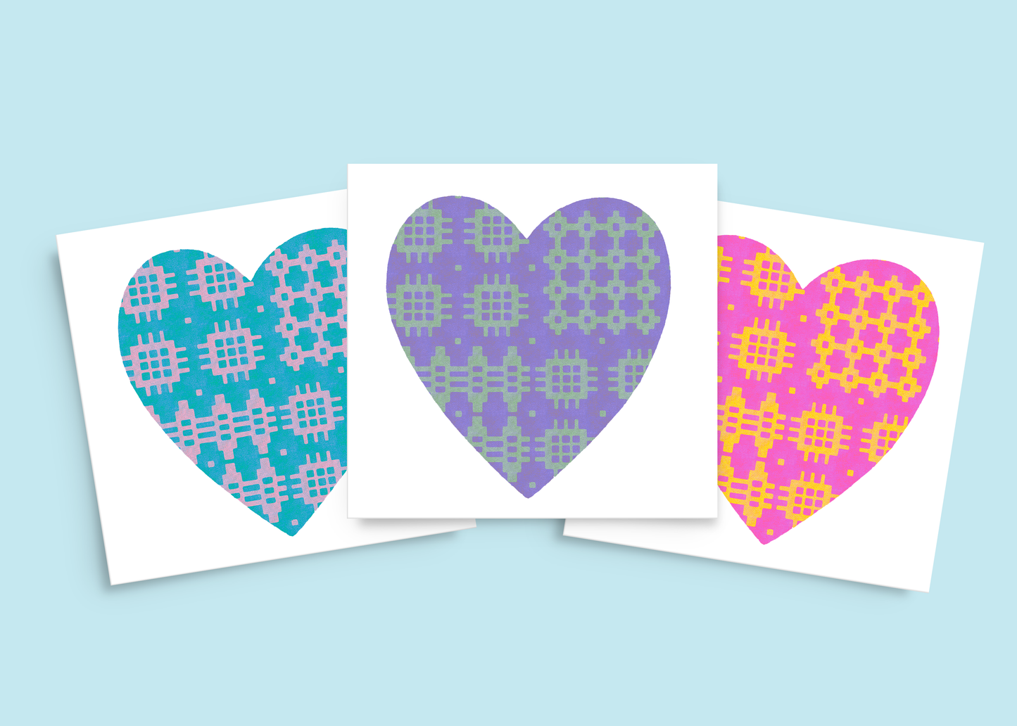 Set of three Welsh birthday cards in pink & yellow, purple & green, and blue & lilac, all featuring traditional blanket pattern hearts.