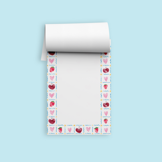 A6 notepad with a cute hearts, cherries, and strawberries design in a squiggle and stars grid. 50 pages, thick paper, eco-friendly