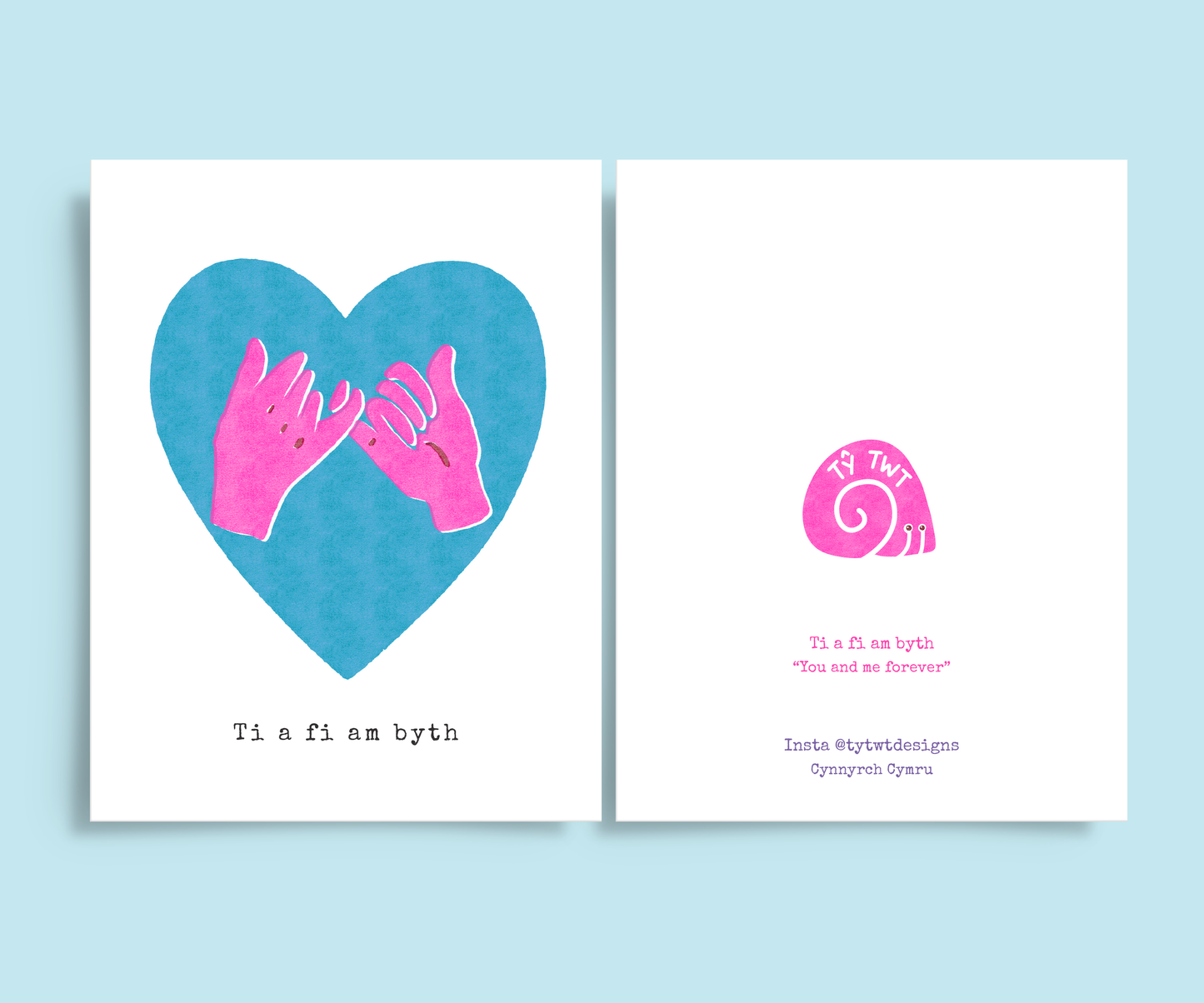 White A6 greeting card. Two bright pink hands pinky promise gesture inside vibrant blue heart shape. Off set risograph print. Typewriter text below says Ti a Fi am Byth. Back of card Ty Twt Designs logo and @tytwtdesigns insatgram and made in Wales