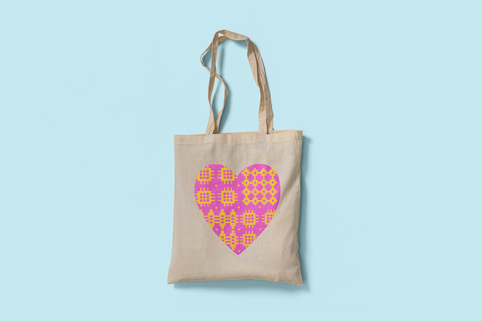 Fair trade cotton tote bag with pink and yellow Welsh blanket heart design printed on both sides. Ethically made and eco-friendly