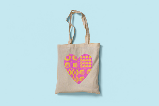 Fair trade cotton tote bag with pink and yellow Welsh blanket heart design printed on both sides. Ethically made and eco-friendly